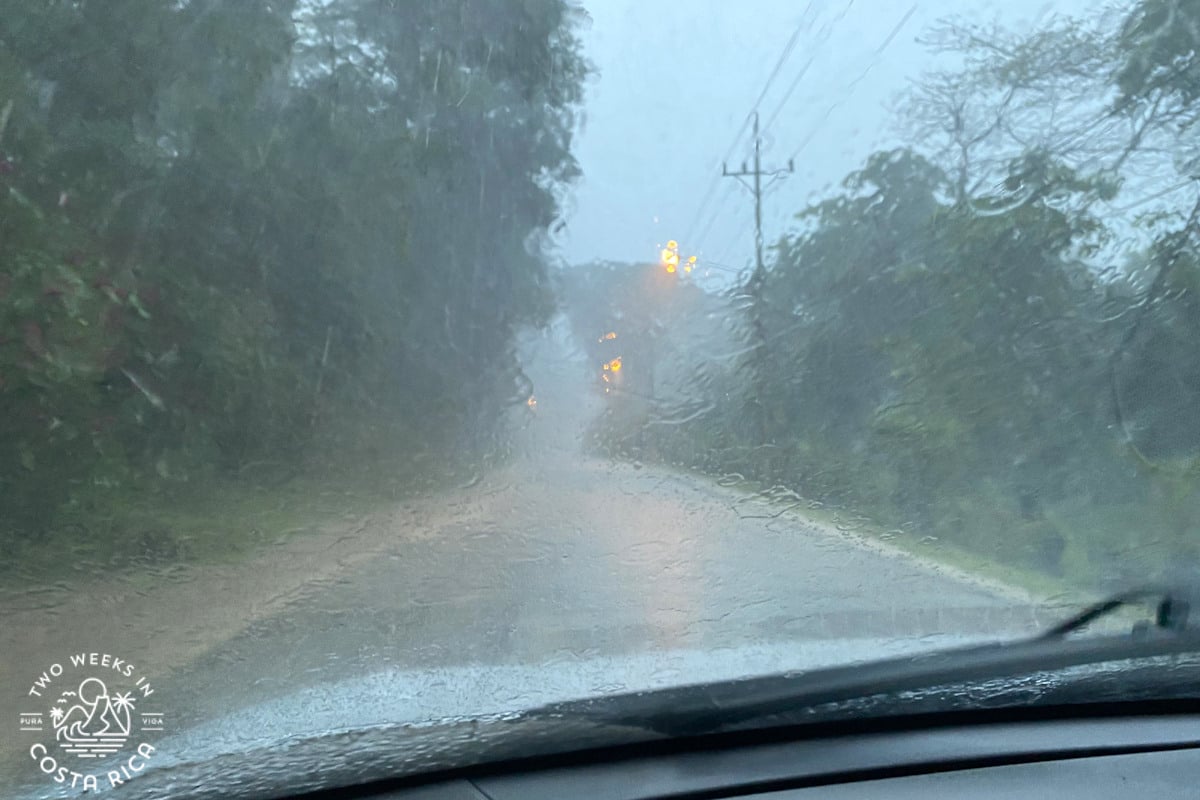 Photo through the windshield of heavy rain and road flooding ahead