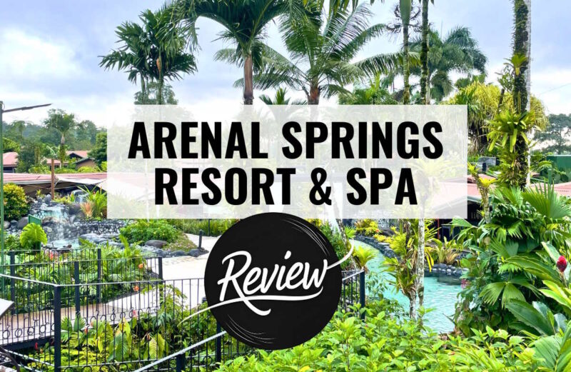 a hotel property with pools palm trees and gardens with text overlay that reads arenal springs resort and spa review