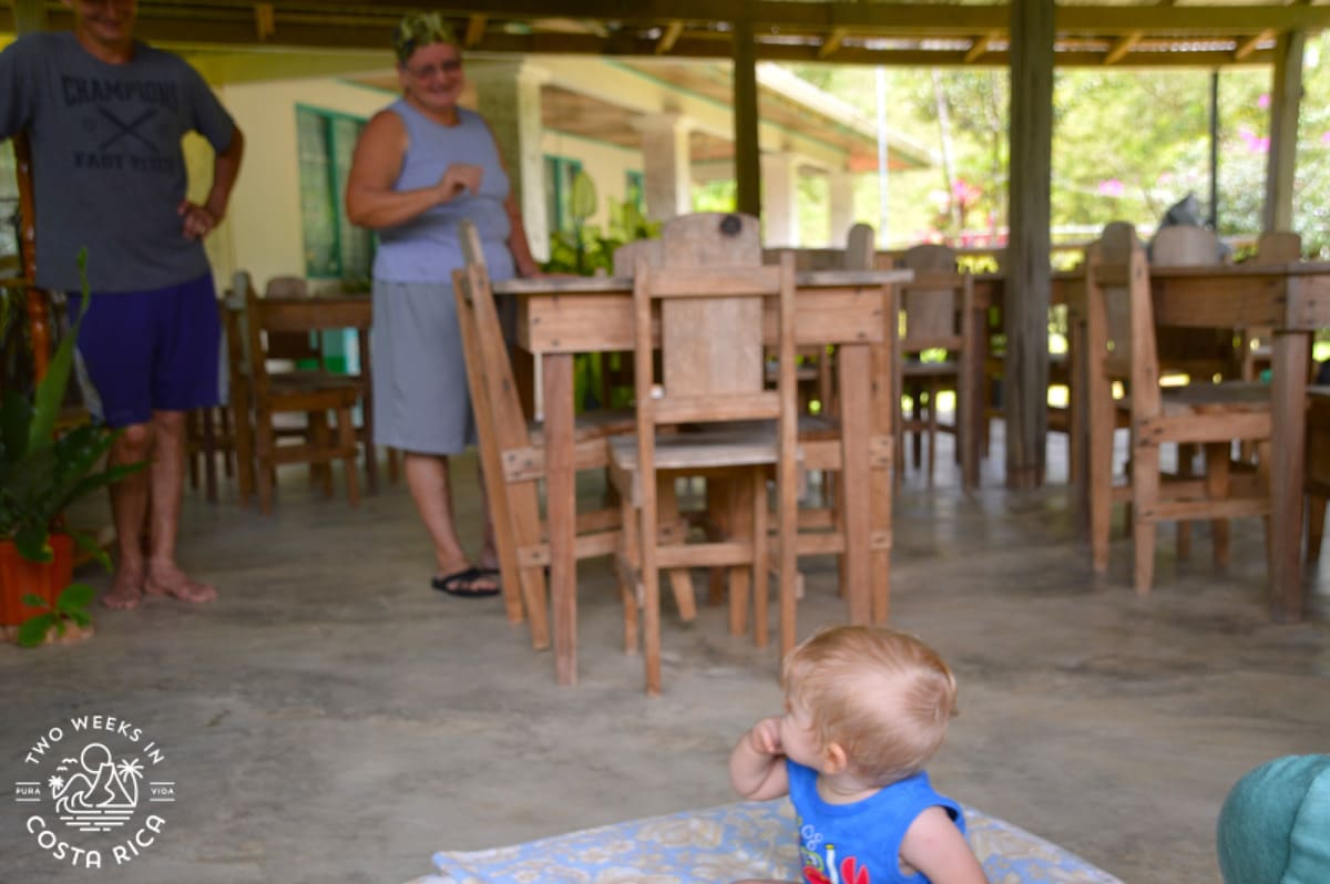 people smiling at a baby in an outdoor restaurant