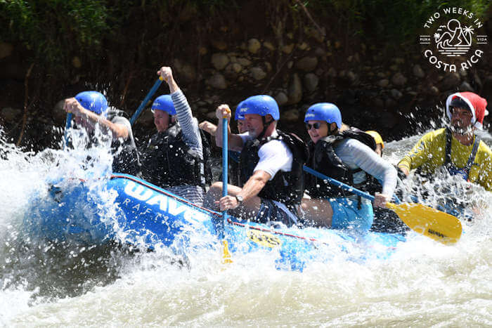 Raft splashing through the river with people paddling