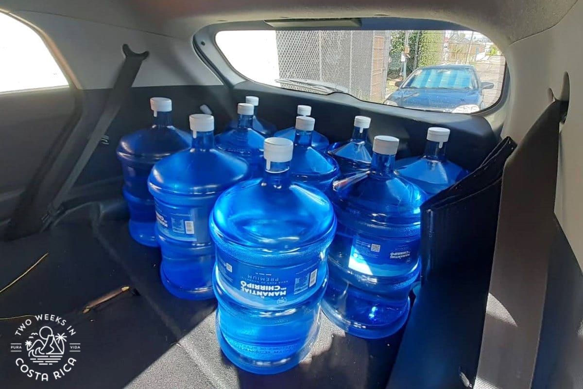 several large water bottles in the back of a car