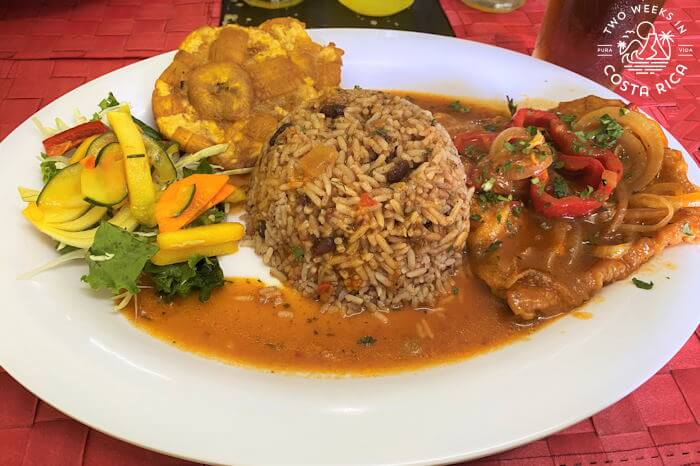 Plate with rice and beans, patacones, fish, and vegetables