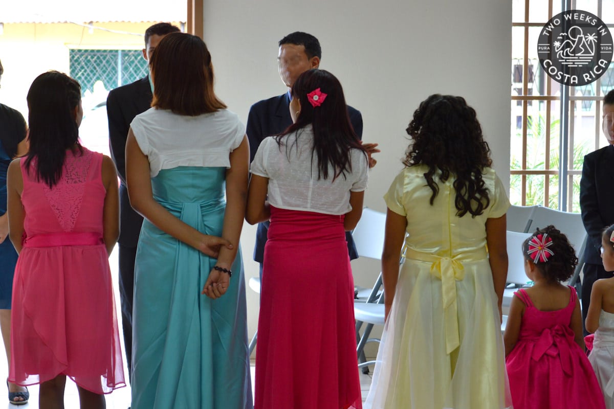 A line of women and girls in pretty dresses attending a wedding Costa Rican