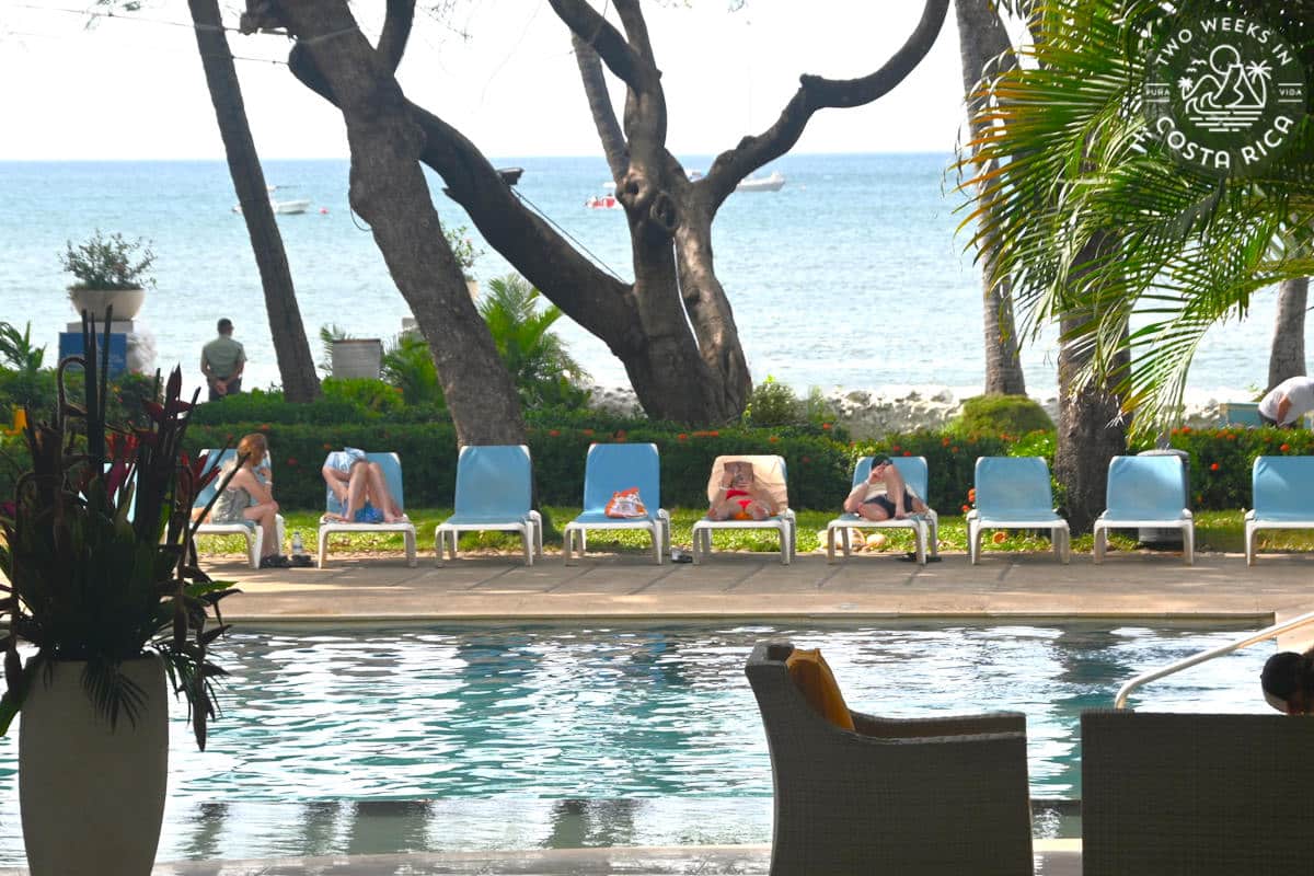 people sitting around a pool on the beach