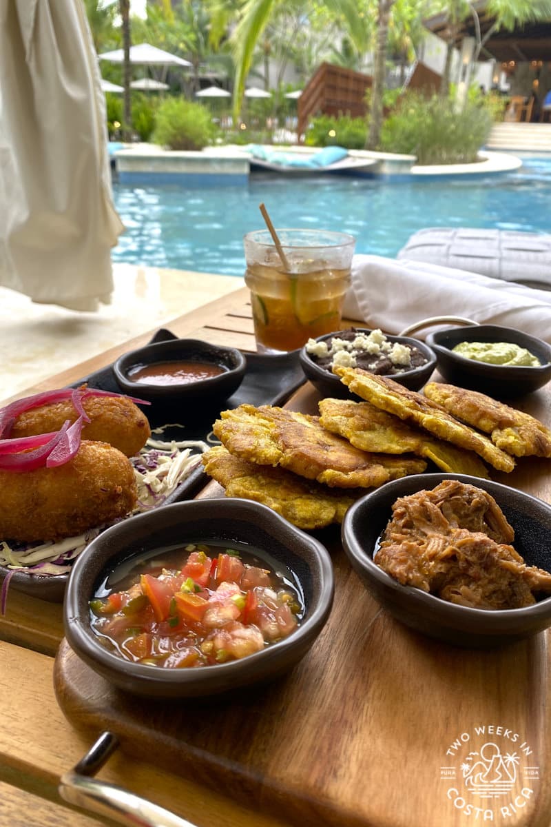 a plate of food on a tray next to a pool