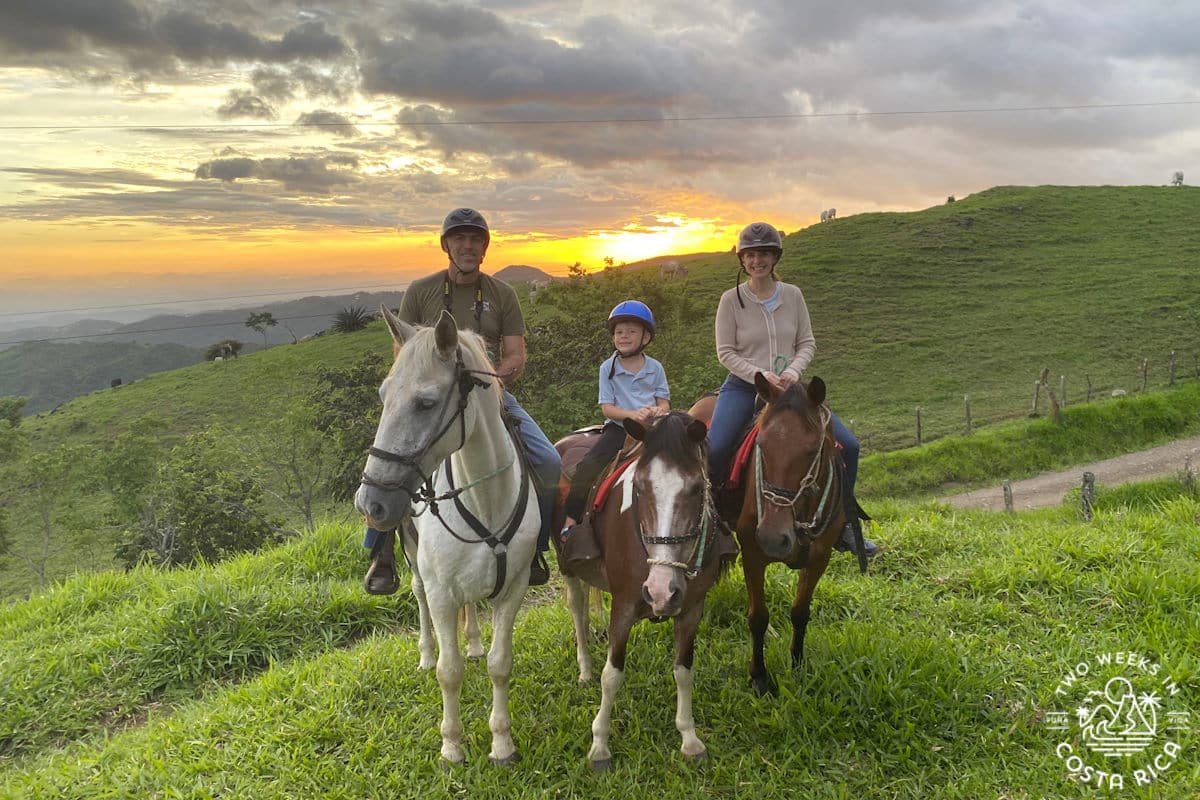 A family on horses posing in front of sunset