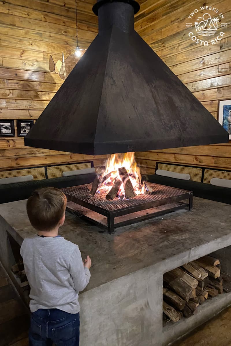 a kid standing next to a fireplace