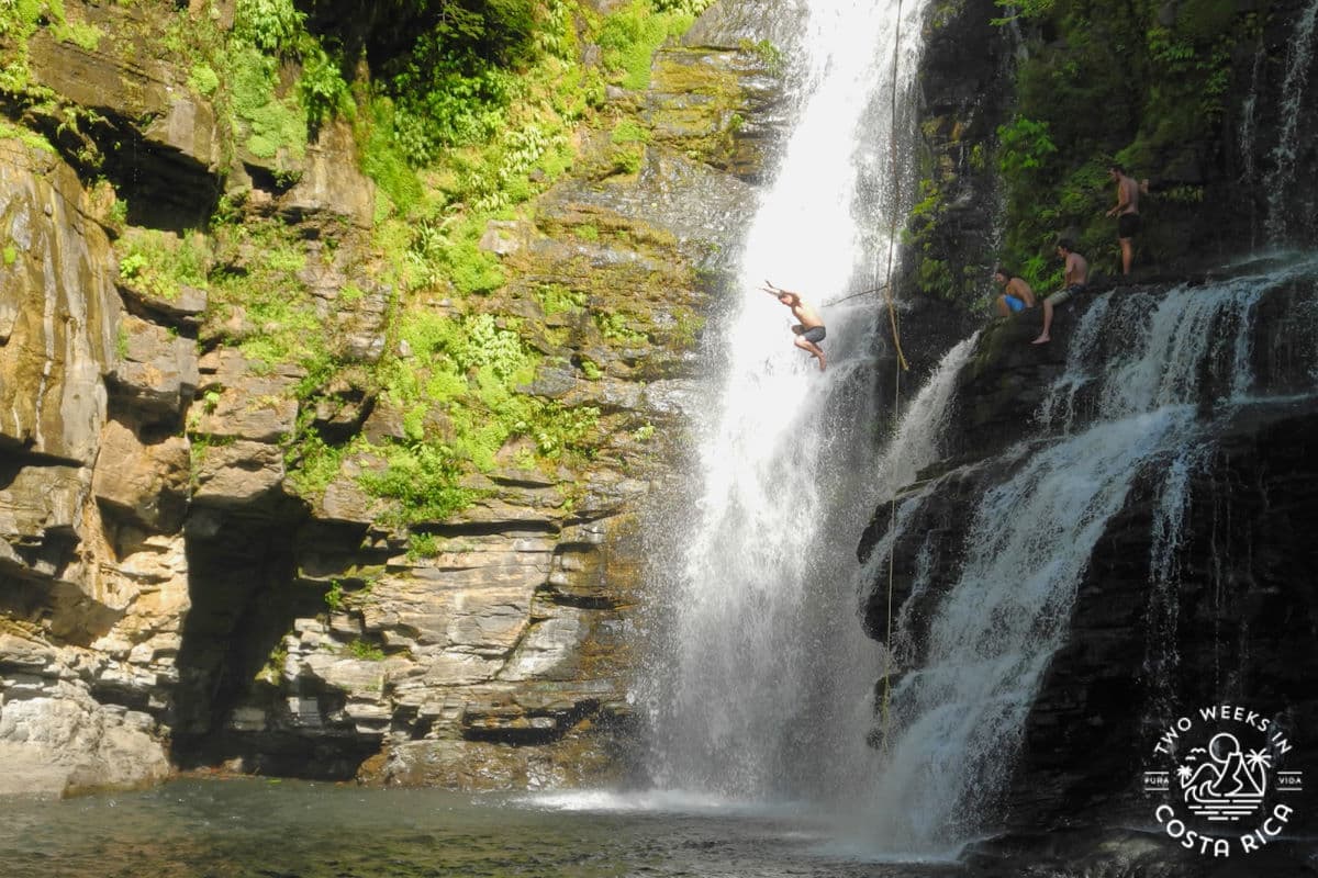 someone jumping into a large waterfall