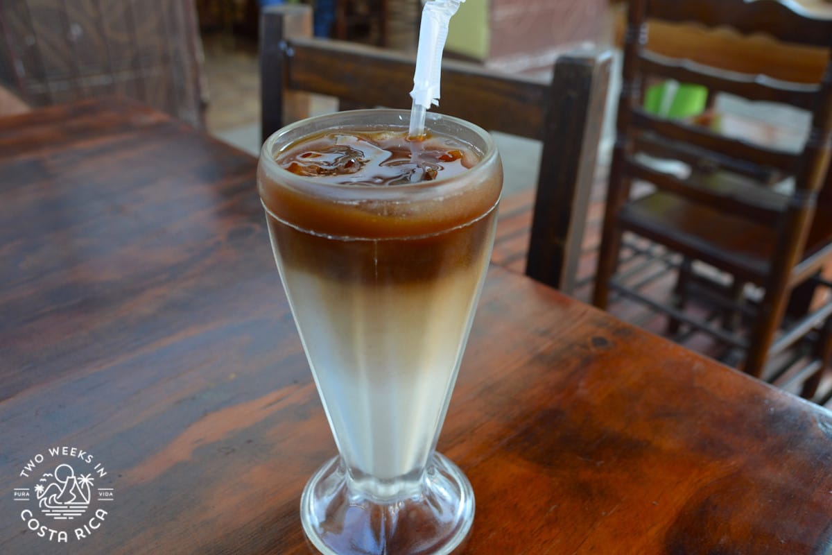 iced coffee in a tall glass with a lot of milk at the bottom