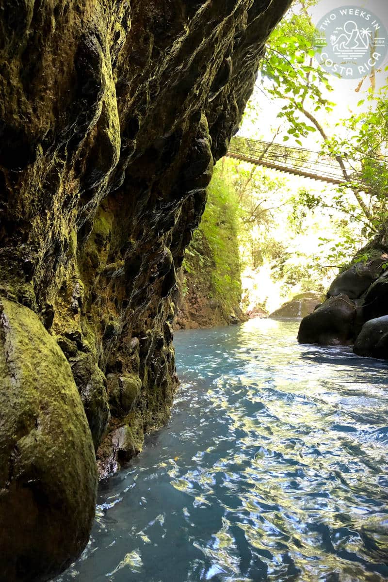 the river at oropendola waterfall with a hanging bridge above