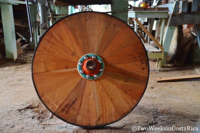 A wooden oxcart wheel without any paint