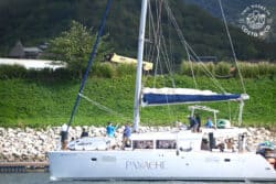 close up of catamaran sailboat with people on it