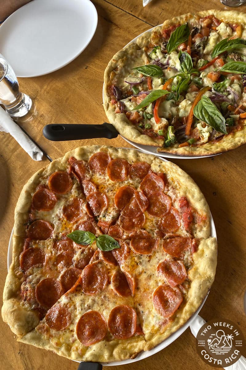 two pizzas on a wooden table
