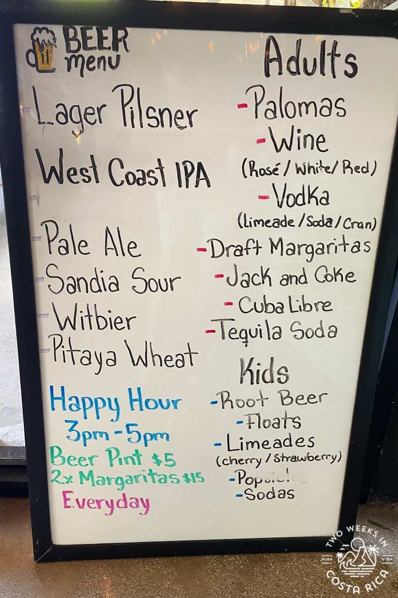 A whiteboard menu with several craft beer choices and specialty drinks
