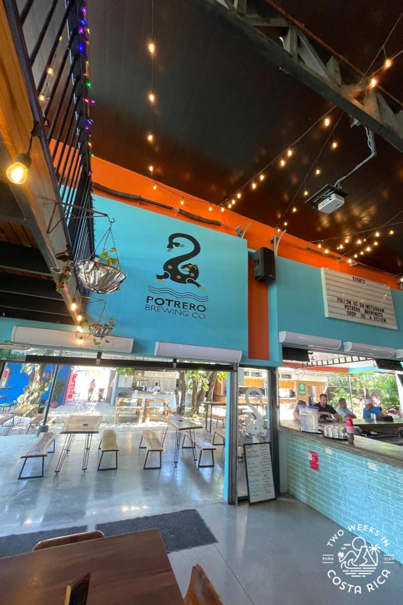 inside a building with turquoise and red walls with a sign that reads potrero brewing company