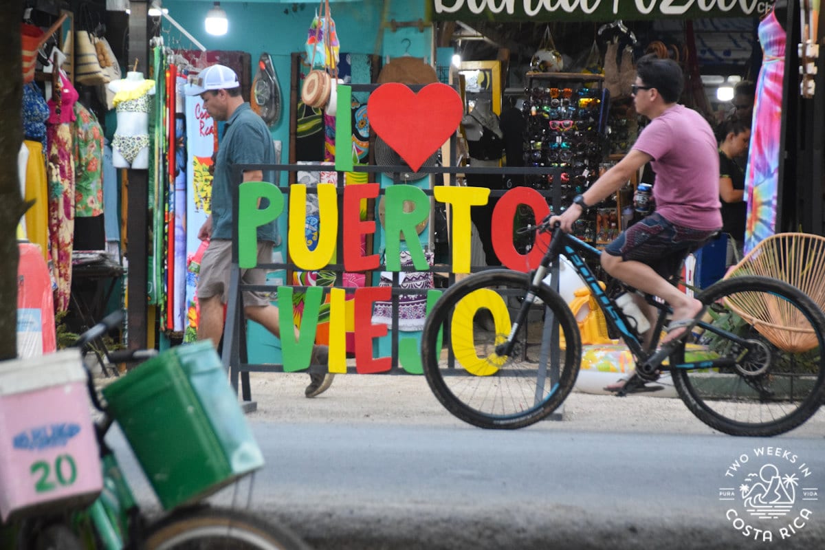 a person on a bike and a sign that reads i love puerto viejo