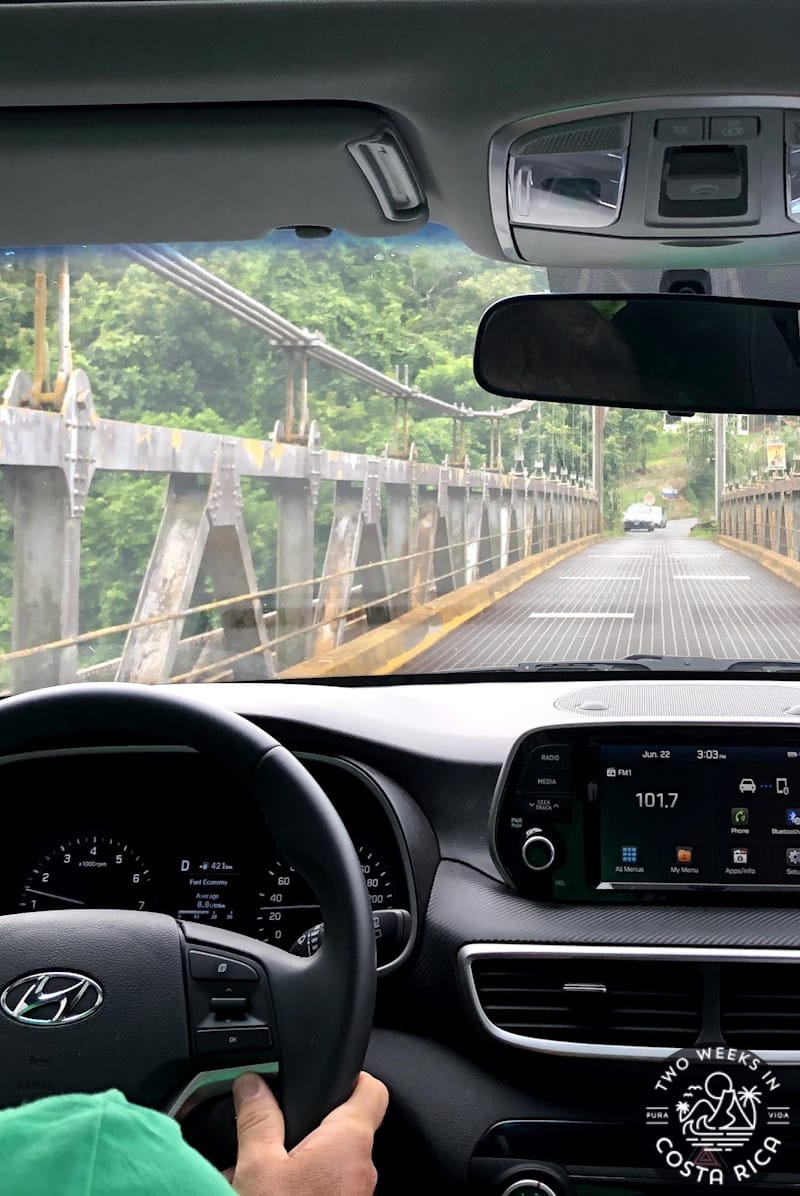 Looking through car windshield at the road and bridge ahead