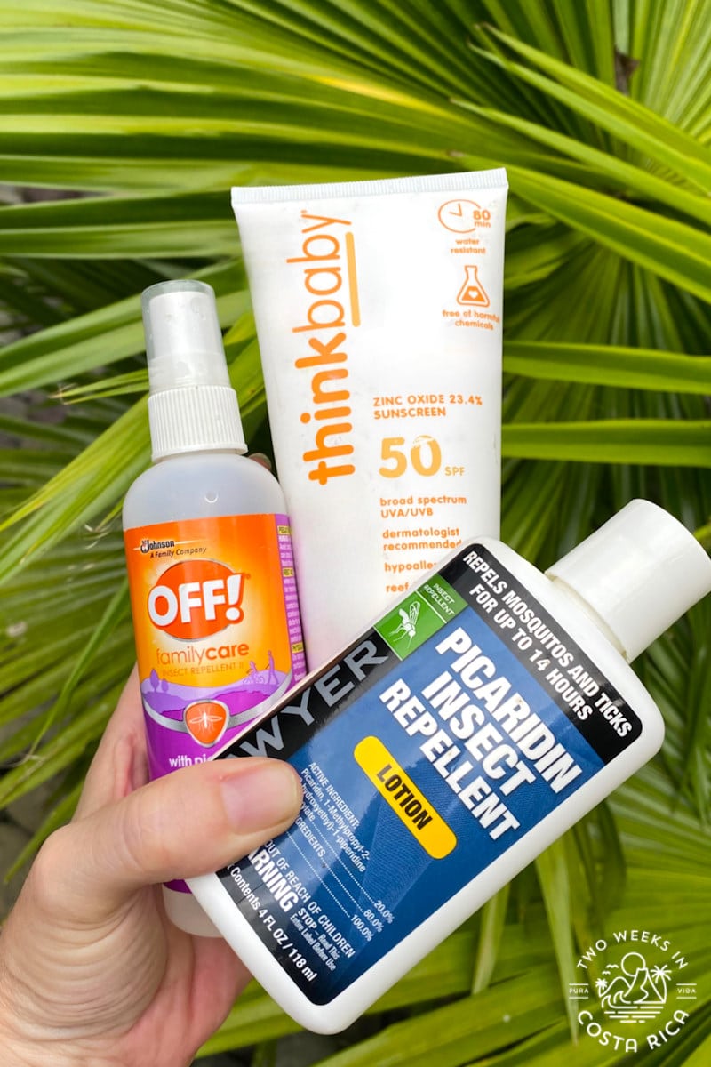 holding a suncreen and insect repellent