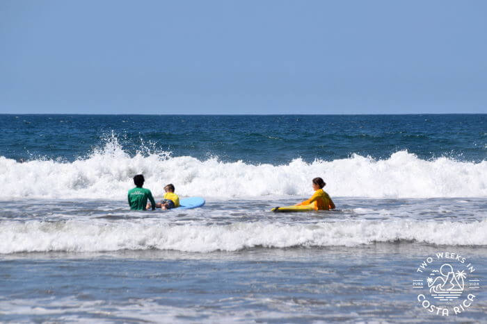 Mom and son paddling out to surf in Playa Grande