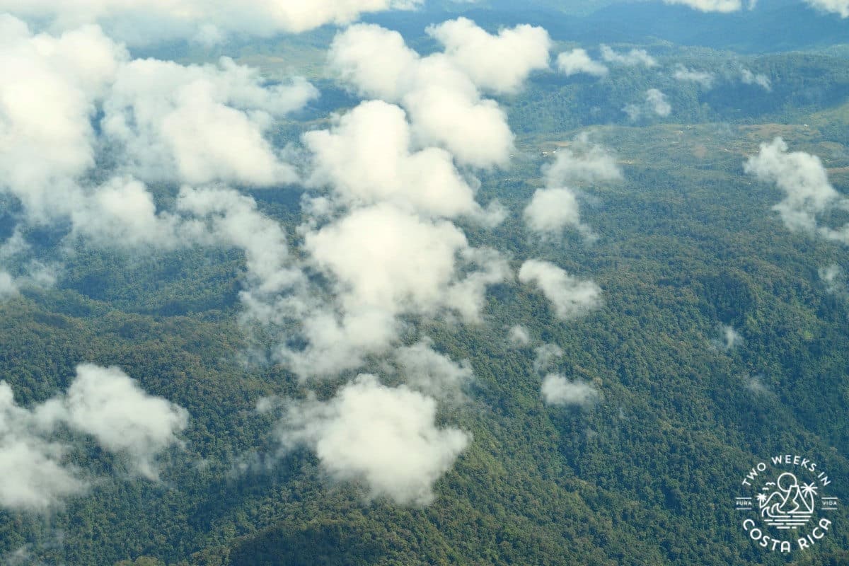a picture taken from the air of green mountains and clouds