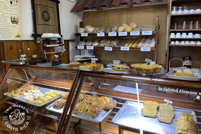 A bakery counter with various breads and pastries 