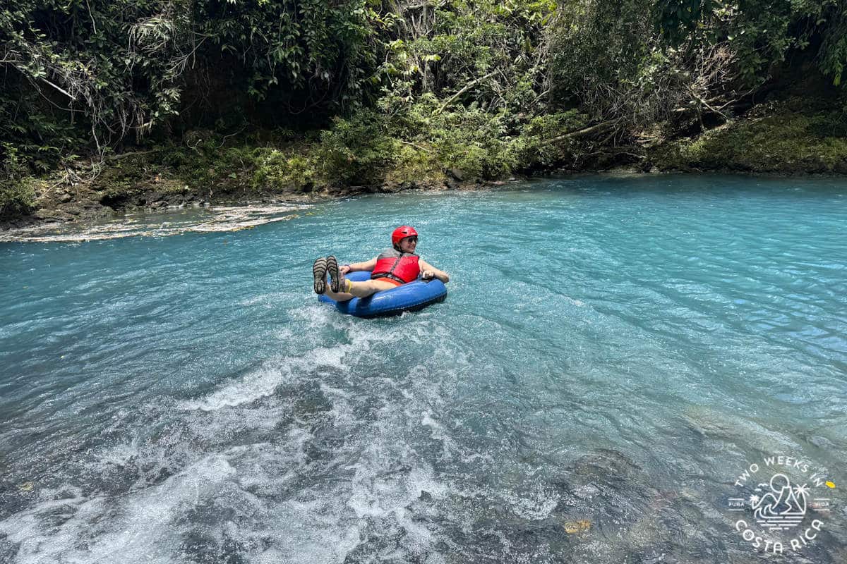 Person tubing down a blue river