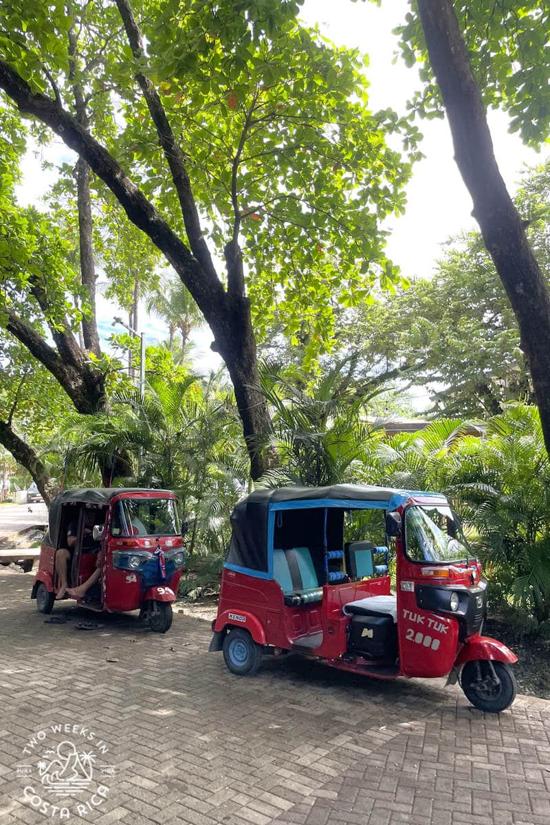 two red tuk tuks parked in playa guiones