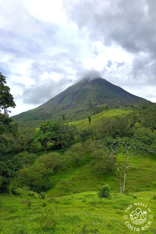 cone shaped volcano with grass in foreground
